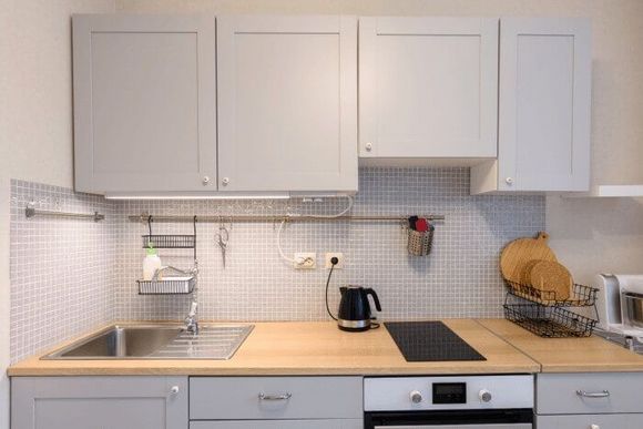 Moderne Küche mit grauen Schränken und Holzarbeitsplatte